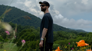 Oleg Zvyagintsev Digital Creator and frequent collaborator for beflo Tenon Sit-Stand Desk in nature with flowers and hill terraine