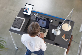 Overhead view of a man standing and working at the Tenon adjustable desk
