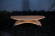 Wooden footrest with a unique design on a dark textured surface
