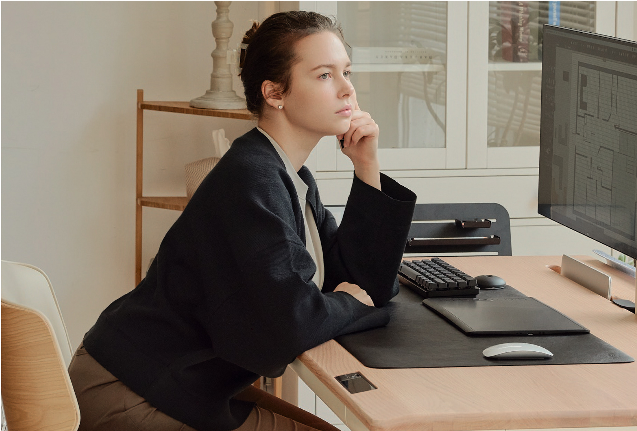 A woman sits at a Tenon Desk from Beflo
