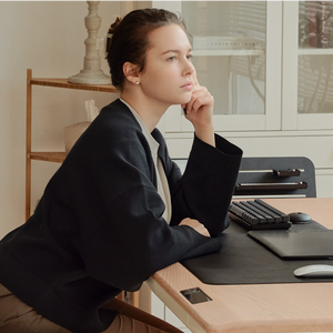 A woman sits at a Tenon Desk from Beflo