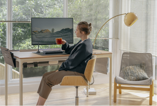 Woman Drinking Out of Mug at Desk